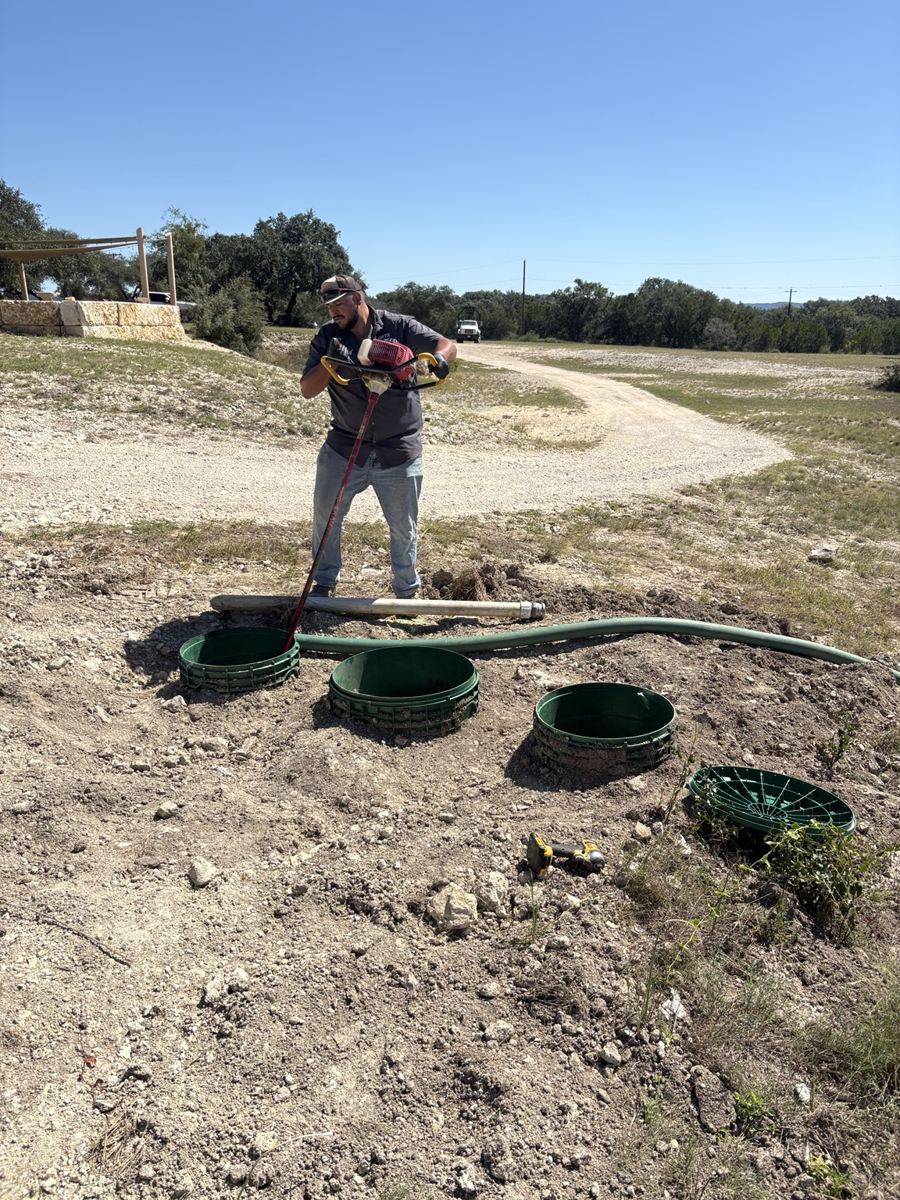 Technician working on exposed septic tank access risers